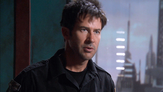 John Sheppard in his black uniform says, "Rodney..." and licks his lips.